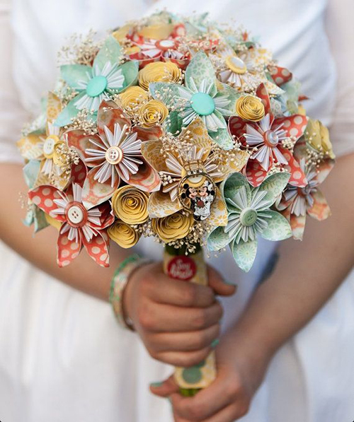 Một bó hoa cưới đẹp với chất liệu giấy in họa tiết đa sắc sặc sỡ kết hợp với phụ kiện nút áo
